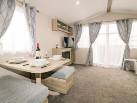 A living room with a dining table and tv at Barney's Retreat in Newquay