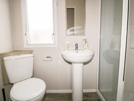 A bathroom with a toilet, sink, and shower at Barney's Retreat in Newquay