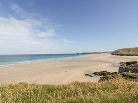 A beach with sand and ocean at Barney's Retreat in Newquay