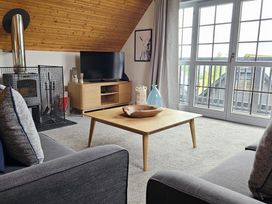 A living room with a fireplace and television at Kinder Lodge 3 Portreath