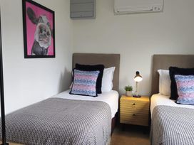 A bedroom with two beds and a painting at Kinder Lodge 3 Portreath