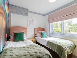 A bedroom with two beds and a fairy tale picture at Kinder Lodge 3 Spa (Pet) Redruth