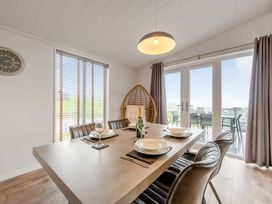 A dining room with a table and chairs at Sonnet 3 Spa in Carmarthen
