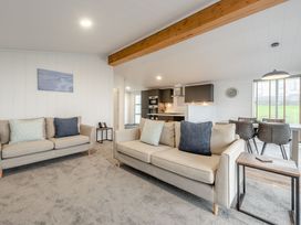 A living room with sofas and a table at Sonnet 3 Spa in Carmarthen