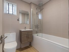 A bathroom with a toilet, bathtub, shower, and sink at Wilde Spa in Carmarthen
