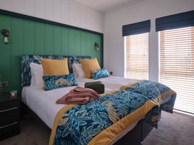 A bedroom with two beds and decorative pillows at Wilde Spa (Pet) Carmarthen