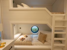 A bedroom with bunk beds and a round window at Wansfell (Pet) Penrith