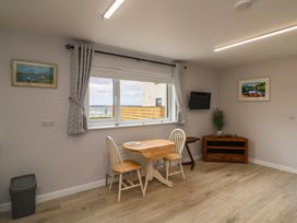 A dining room with a table and chairs at Radharc an Hook @ Estuary Bliss