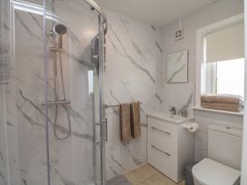 A bathroom with shower, sink, toilet, and towels at Radharc an Hook @ Estuary Bliss