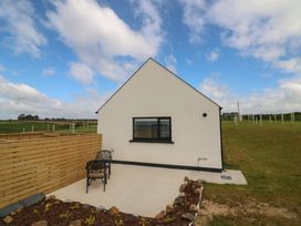 An outdoor area with a house and chairs at Radharc an Hook @ Estuary Bliss