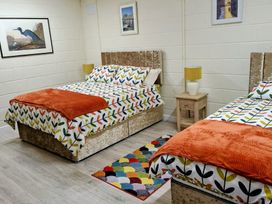 A bedroom with two beds and a bedside table at Radharc an Hook @ Estuary Bliss, Duncannon, County Wexford