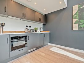 A kitchen with cabinets, oven, sink and utensils at Arvor Studio 1.0 in Bude