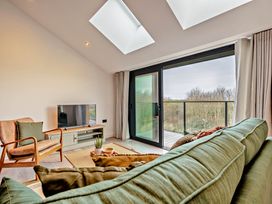 A living room with a sofa and television at Walesborough Penthouse 2.0 in Marhamchurch