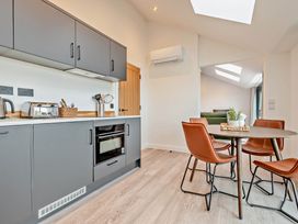 A kitchen with cabinets and dining area at Walesborough Penthouse 2.0 in Marhamchurch