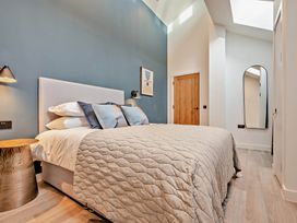 A bedroom with a bed, bedside table, and mirror at Walesborough Penthouse 2.0 in Marhamchurch