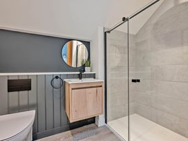 A bathroom with a washbasin, mirror, and shower at Walesborough Penthouse 2.0 in Marhamchurch