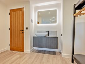 A bathroom with a sink and mirror at Whalesborough Penthouse 2.0 Marhamchurch