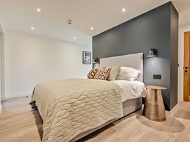 A bedroom with a bed and nightstand at Whalesborough Penthouse 2.0 in Marhamchurch