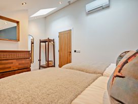 A bedroom with two beds and a mirror at Whalesborough Penthouse 2.0 Marhamchurch
