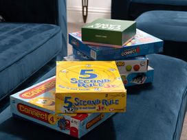 A stack of board games on a couch at Tides Door in Dartmouth