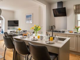 A kitchen with a dining table and flowers at Tides Door in Dartmouth