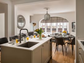 A kitchen with a dining table and chairs at Tides Door in Dartmouth