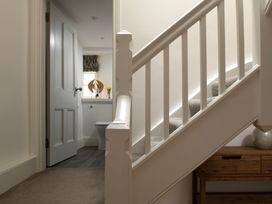 A hallway with a staircase and a wooden console table at Tides Door in Dartmouth