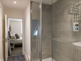 A bathroom with a shower and a view of a bedroom at Tides Door in Dartmouth