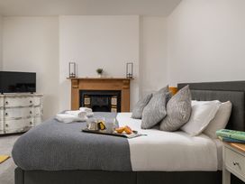 A bedroom with a bed, television, and fireplace at Tides Door in Dartmouth