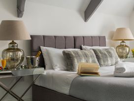 A bedroom with a bed, lamps, and decorative items at Tides Door in Dartmouth