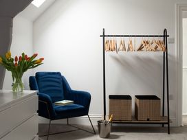 A bedroom with a chair, hanger rack, and flower vase at Tides Door in Dartmouth