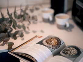 A kitchen with a book open and coffee cups at 28 Piazza St Ives