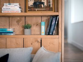 A living room with books and a plant on a shelf at 28 Piazza St Ives