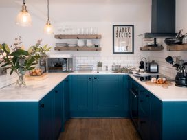 A kitchen with blue cabinets and appliances at 28 Piazza in St Ives