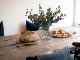 A dining table with bread and eucalyptus at 28 Piazza St Ives