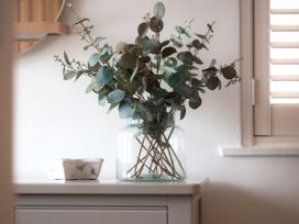 A decorative arrangement of eucalyptus in a vase on a table at 28 Piazza St Ives