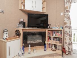 A living room with a television and decorative items at 37 Redcar
