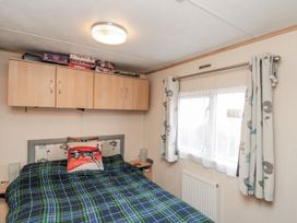 A bedroom with a bed and shelves at 37 Redcar