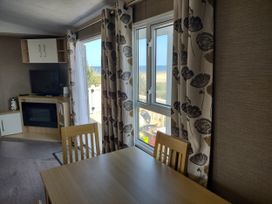 A dining room with a table and chairs at Sands Retreat in Redcar