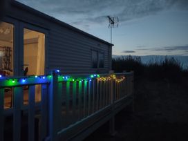 An outdoor view of a mobile home with fairy lights at Sands Retreat in Redcar