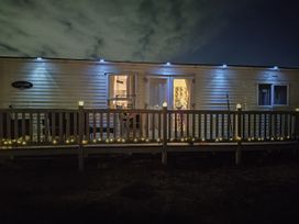A mobile home with a deck and lights at Sands Retreat in Redcar