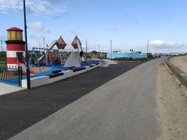 A playground with a lighthouse, swings, and slides at Sands Retreat in Redcar