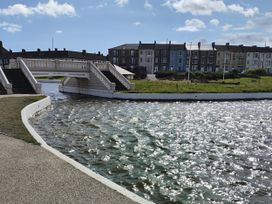 A view of a bridge over water with buildings in the background at Sands Retreat in Redcar