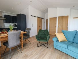 A living room with a dining area and kitchen at Grass Roots 