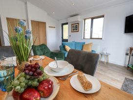 A dining room with a table set and living area in view at Grass Roots
