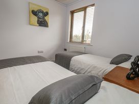 A bedroom with two beds and a painting at Grass Roots