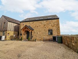 An outdoor view of a stone building with a gravel area at The Joiners Cottage in Birling near Warkworth
