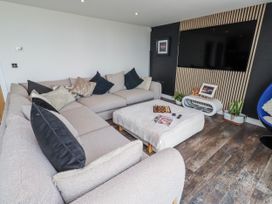 A living room with a sofa and TV at The Joiners Cottage Birling near Warkworth