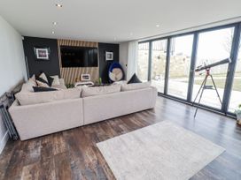 A living room with a sofa and telescope at The Joiners Cottage Birling near Warkworth