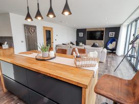 A living room with a kitchen island and seating area at The Joiners Cottage in Birling near Warkworth